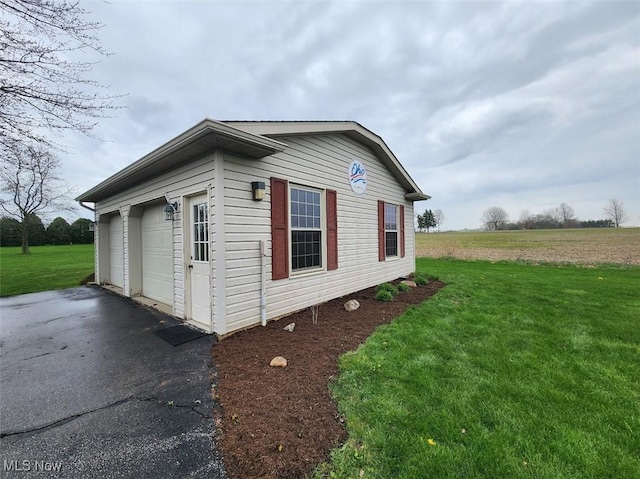 view of side of property with a lawn and a garage