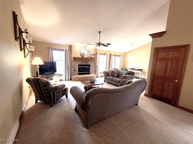 living area featuring a healthy amount of sunlight, a ceiling fan, baseboards, and light colored carpet