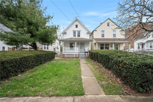 view of front facade featuring fence, a front yard, and covered porch
