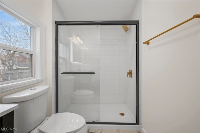 bathroom with toilet and a stall shower