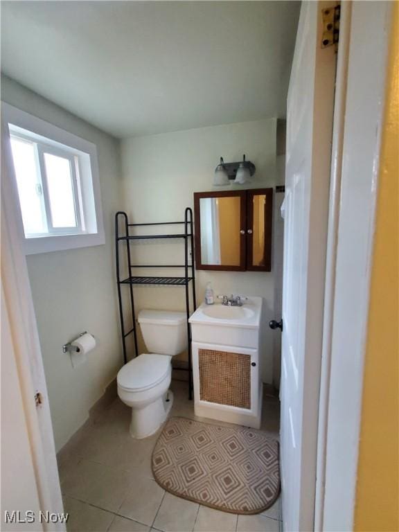bathroom with toilet, tile patterned flooring, and vanity