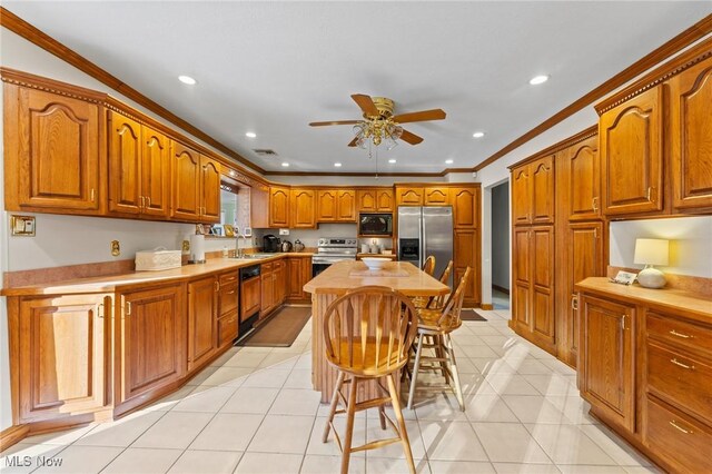 148 N Kimberly Ave N, Youngstown, OH 44515 - kitchen with stainless steel appliances, brown cabinets, a ceiling fan, crown molding, and recessed lighting