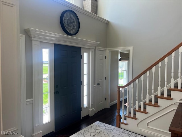 entrance foyer featuring baseboards, a towering ceiling, dark wood-type flooring, and stairway