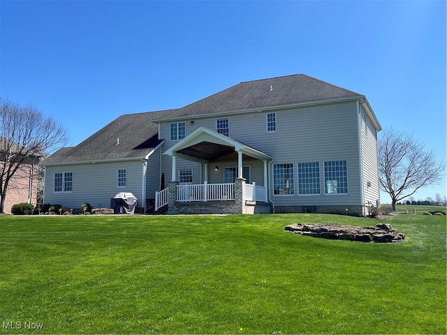 back of property with a lawn and covered porch