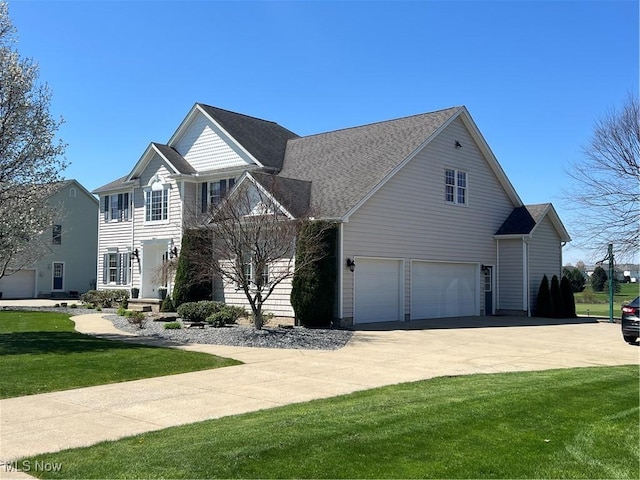 view of front of home featuring a garage, driveway, and a front yard