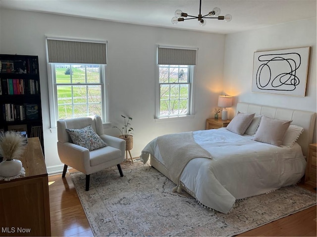 bedroom featuring wood finished floors and a chandelier
