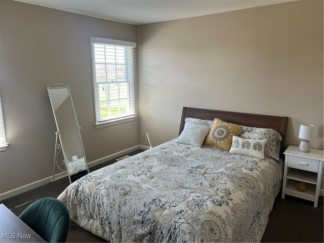 bedroom featuring dark colored carpet and baseboards