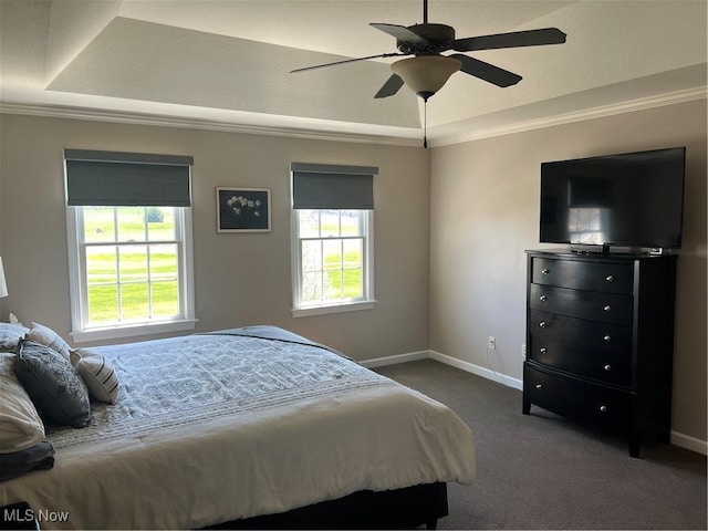 bedroom with ornamental molding, baseboards, dark carpet, and a raised ceiling