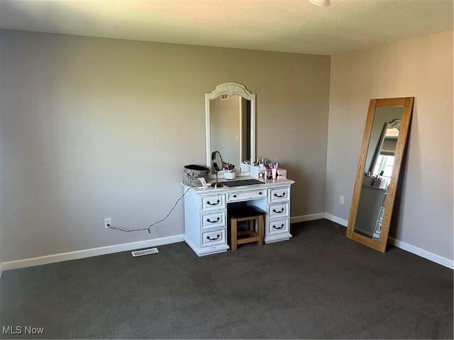 unfurnished bedroom featuring visible vents, baseboards, and dark carpet