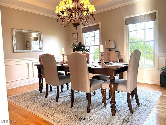 dining area featuring a wealth of natural light, ornamental molding, hardwood / wood-style flooring, and a notable chandelier