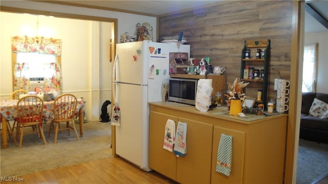 46 Navajo, Creston, OH 44217 - kitchen with stainless steel microwave, freestanding refrigerator, light wood-style floors, a chandelier, and wooden walls