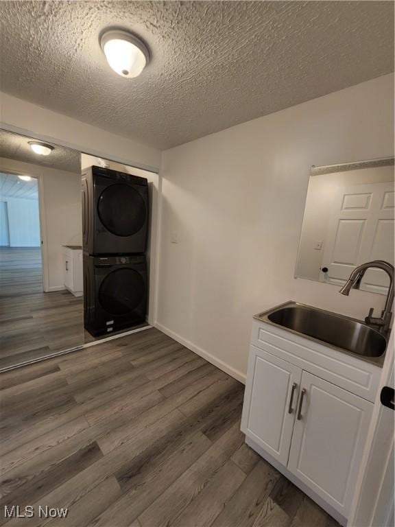 1490 Evergreen Dr, Streetsboro, OH 44241 - washroom with stacked washer / drying machine, baseboards, a sink, and dark wood-style flooring