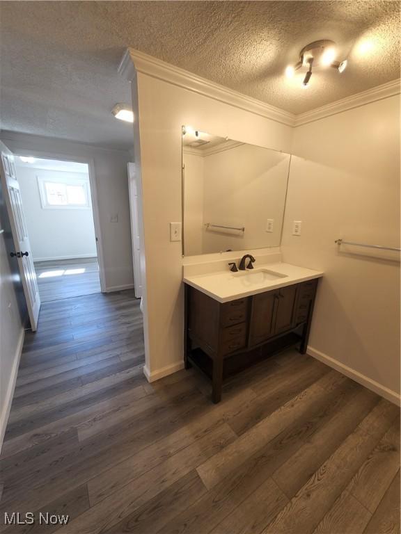 1490 Evergreen Dr, Streetsboro, OH 44241 - bathroom with crown molding, wood finished floors, a textured ceiling, vanity, and baseboards