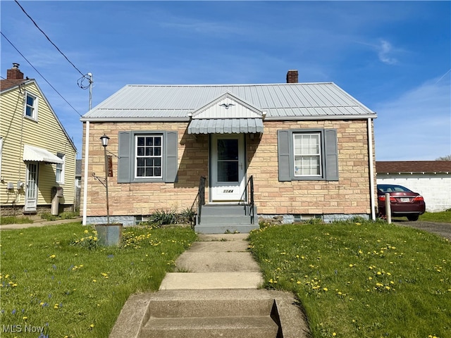 1144 Homewood Ave SW, Canton, OH 44710 - bungalow with a chimney, entry steps, a front yard, and metal roof