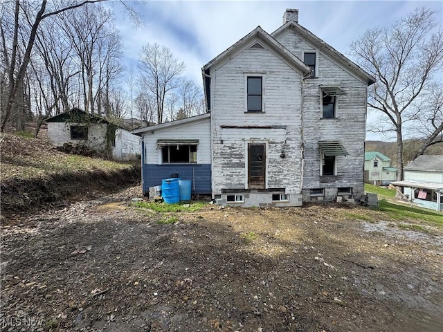 back of house with a chimney