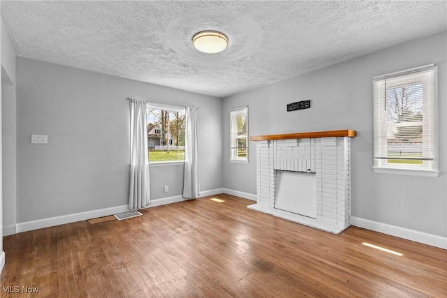 120 Hillcrest Dr, Wellsburg, WV 26070 - unfurnished living room featuring a textured ceiling, baseboards, visible vents, hardwood / wood-style floors, and a fireplace