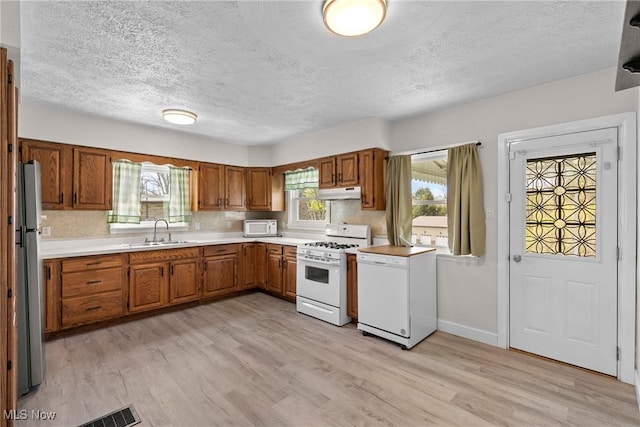 120 Hillcrest Dr, Wellsburg, WV 26070 - kitchen featuring a sink, white appliances, light wood-type flooring, brown cabinetry, and a textured ceiling