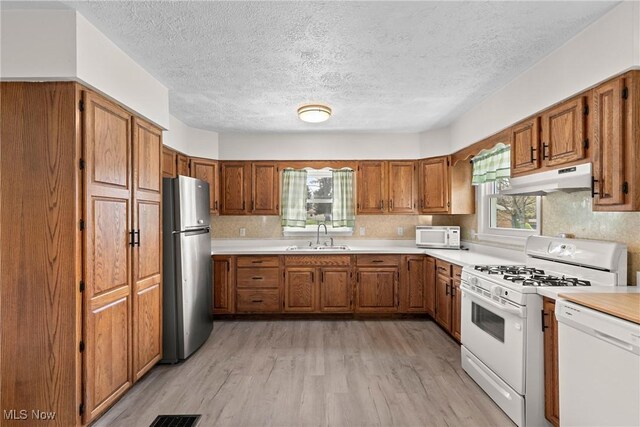120 Hillcrest Dr, Wellsburg, WV 26070 - kitchen with brown cabinetry, light wood finished floors, under cabinet range hood, and white appliances