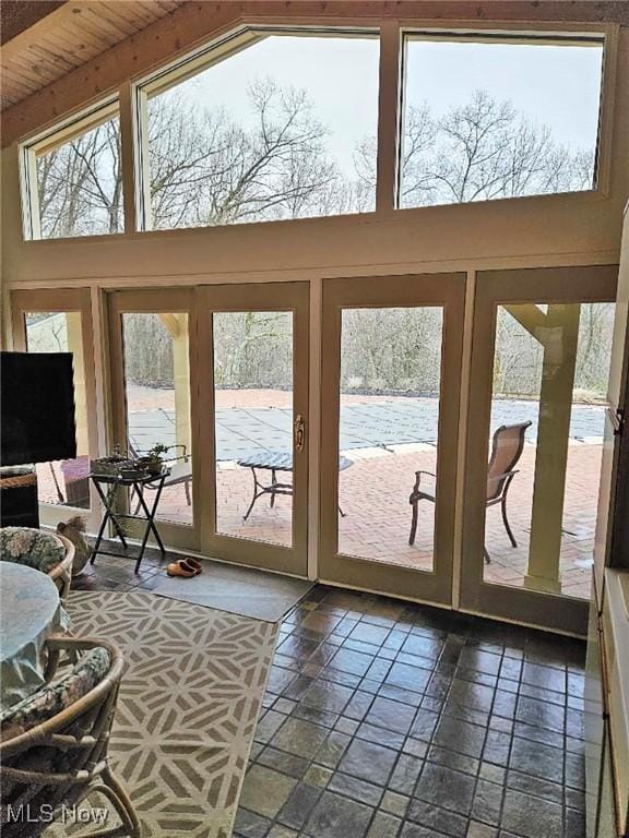 entryway with stone tile floors and high vaulted ceiling