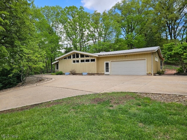 805 Lynnwood Dr, Minerva, OH 44657 - mid-century home with concrete driveway, a garage, and metal roof