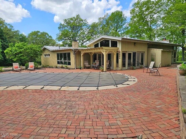 805 Lynnwood Dr, Minerva, OH 44657 - back of house with a chimney, a patio area, and a covered pool