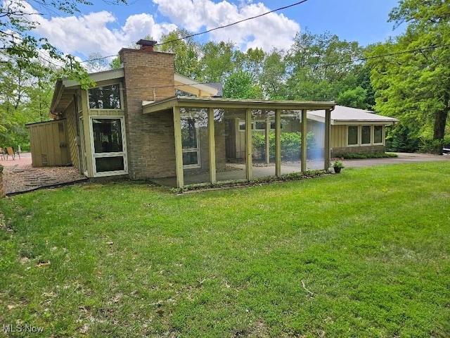 805 Lynnwood Dr, Minerva, OH 44657 - back of property featuring a chimney, a sunroom, and a lawn