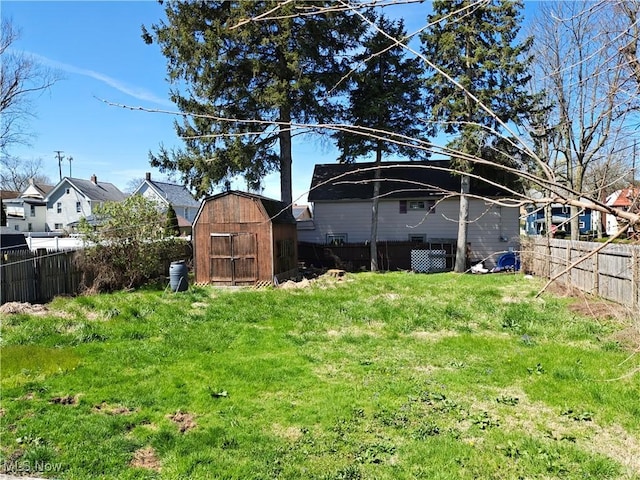 view of yard featuring a fenced backyard, an outdoor structure, and a shed