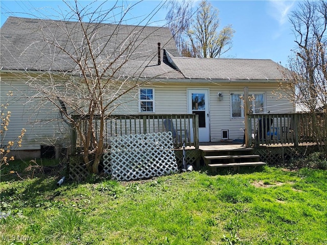rear view of house featuring a shingled roof and a deck