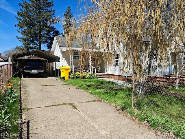 view of front of property with fence, driveway, and a detached carport
