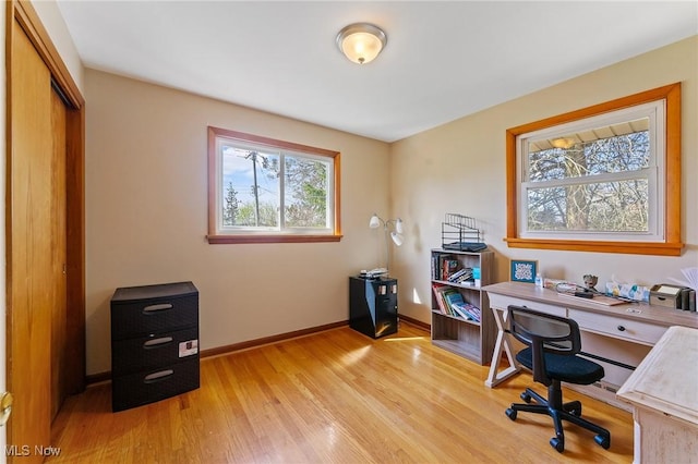 office space featuring baseboards and light wood finished floors