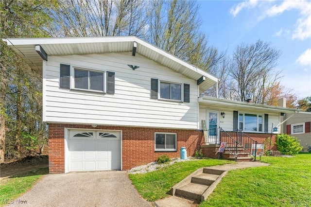 tri-level home with brick siding, a front yard, aphalt driveway, and a garage