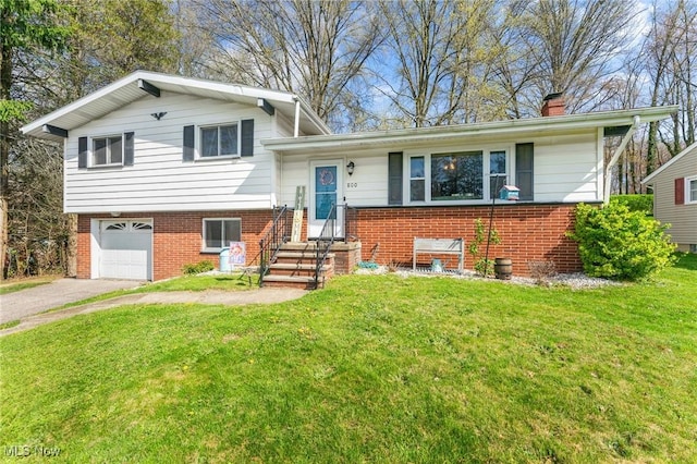 tri-level home featuring a chimney, a front lawn, aphalt driveway, a garage, and brick siding