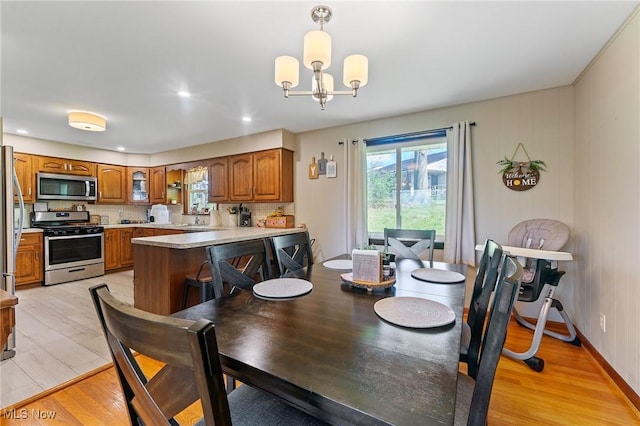 dining room with a chandelier and light wood finished floors