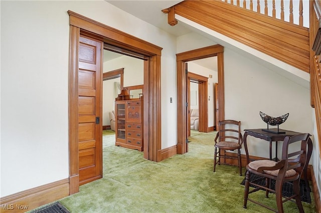 hall with baseboards and carpet flooring