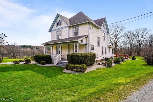 victorian-style house with a front yard and covered porch