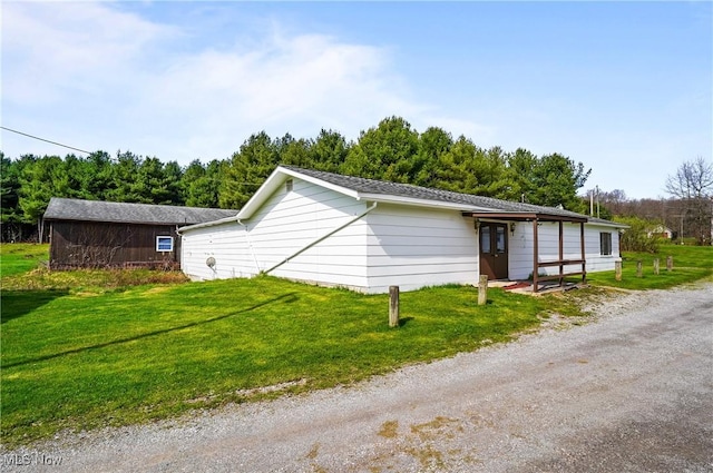 view of side of home with a yard