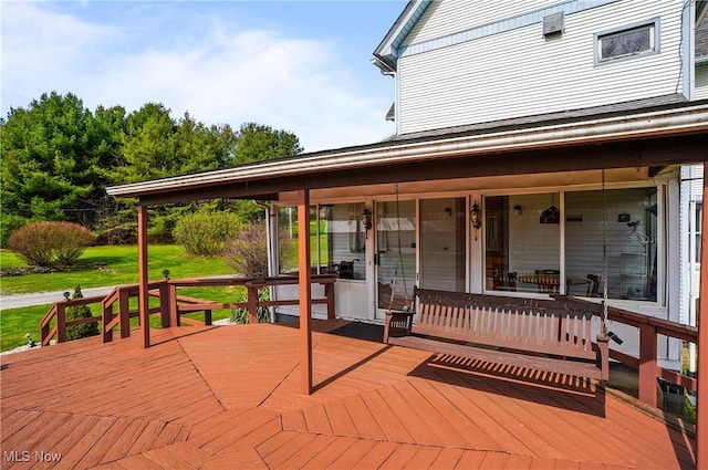 wooden terrace featuring a lawn