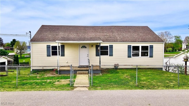 view of front of house featuring a gate, roof with shingles, a front lawn, and a fenced front yard