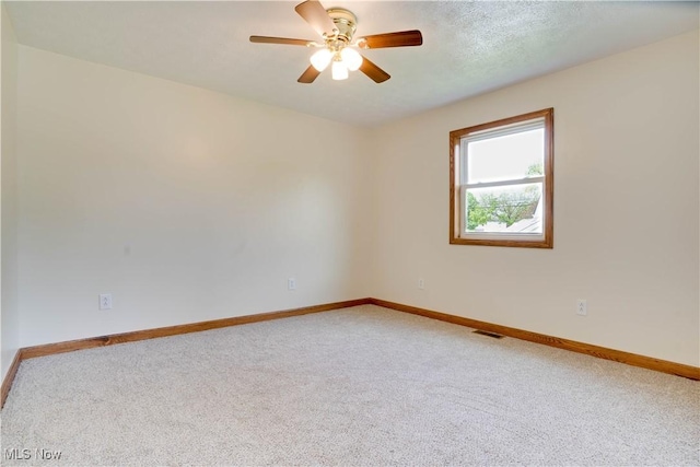 empty room featuring ceiling fan, baseboards, carpet flooring, and visible vents