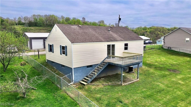 rear view of property featuring a wooden deck, a lawn, a fenced backyard, and stairs