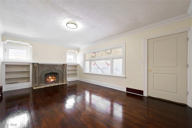 unfurnished living room featuring crown molding, wood finished floors, a textured ceiling, baseboards, and a brick fireplace