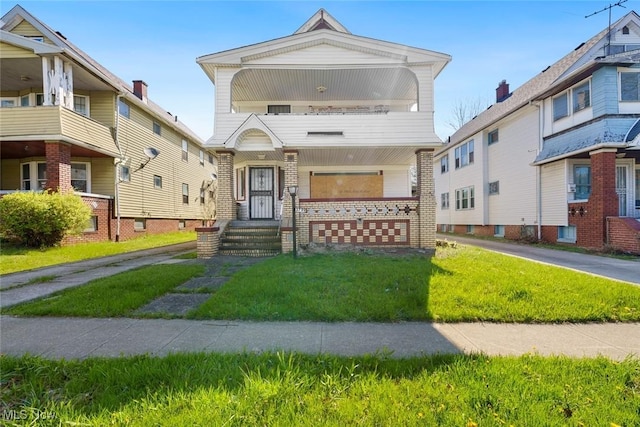 view of front facade with brick siding and a front lawn