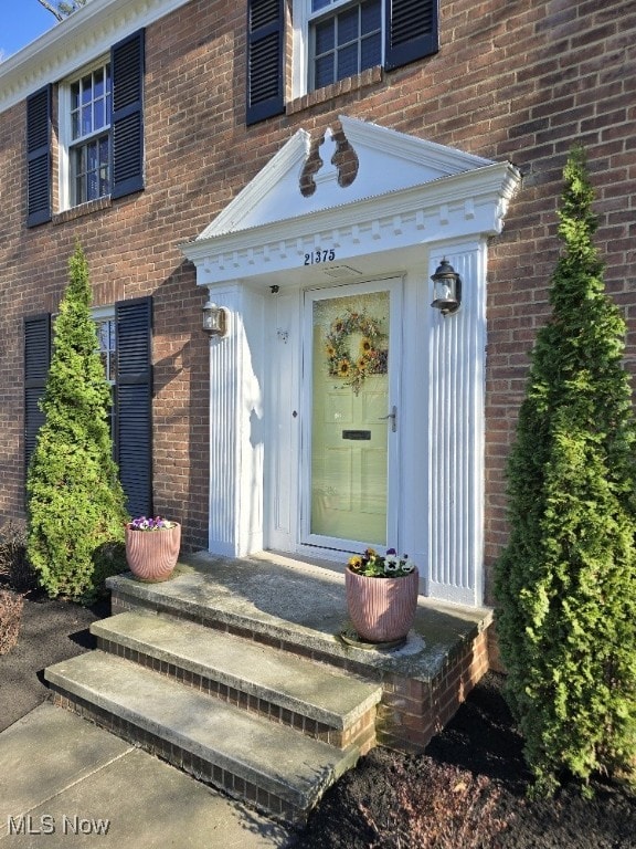 view of exterior entry with brick siding