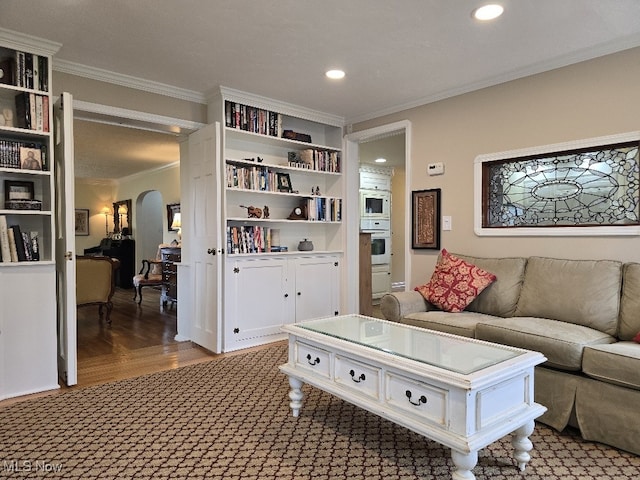 carpeted living room featuring arched walkways, ornamental molding, and recessed lighting
