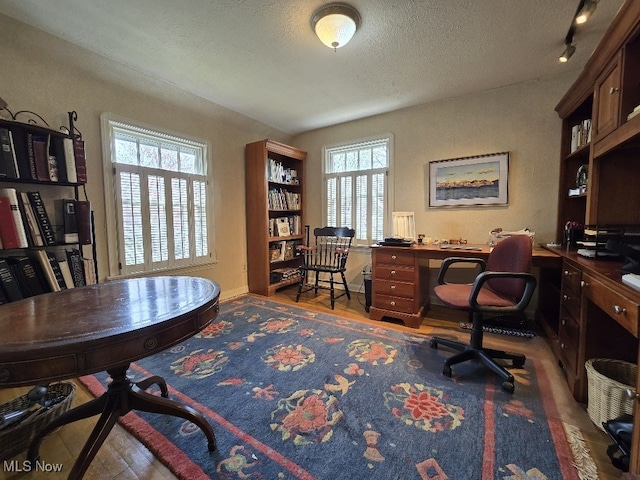 office with wood finished floors and a textured ceiling