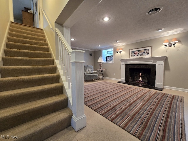 interior space with a high end fireplace, visible vents, ornamental molding, baseboards, and stairs