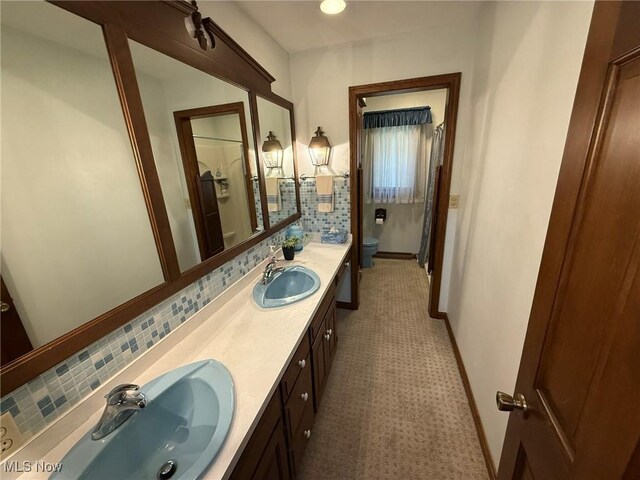 2476 Willow Brook Dr NW, Dover, OH 44622 - bathroom with double vanity, toilet, decorative backsplash, and a sink