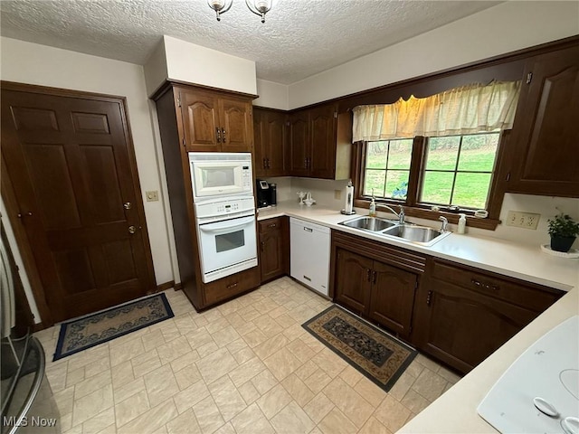 2476 Willow Brook Dr NW, Dover, OH 44622 - kitchen featuring light countertops, dark brown cabinetry, a sink, and white appliances
