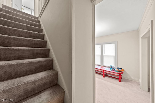 stairs with carpet floors, ornamental molding, and baseboards