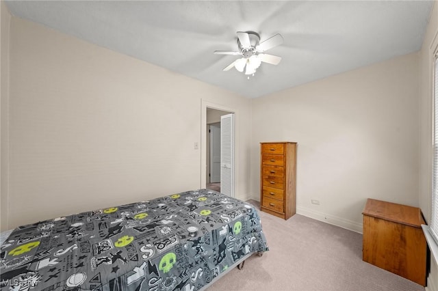 bedroom with light colored carpet, baseboards, and a ceiling fan